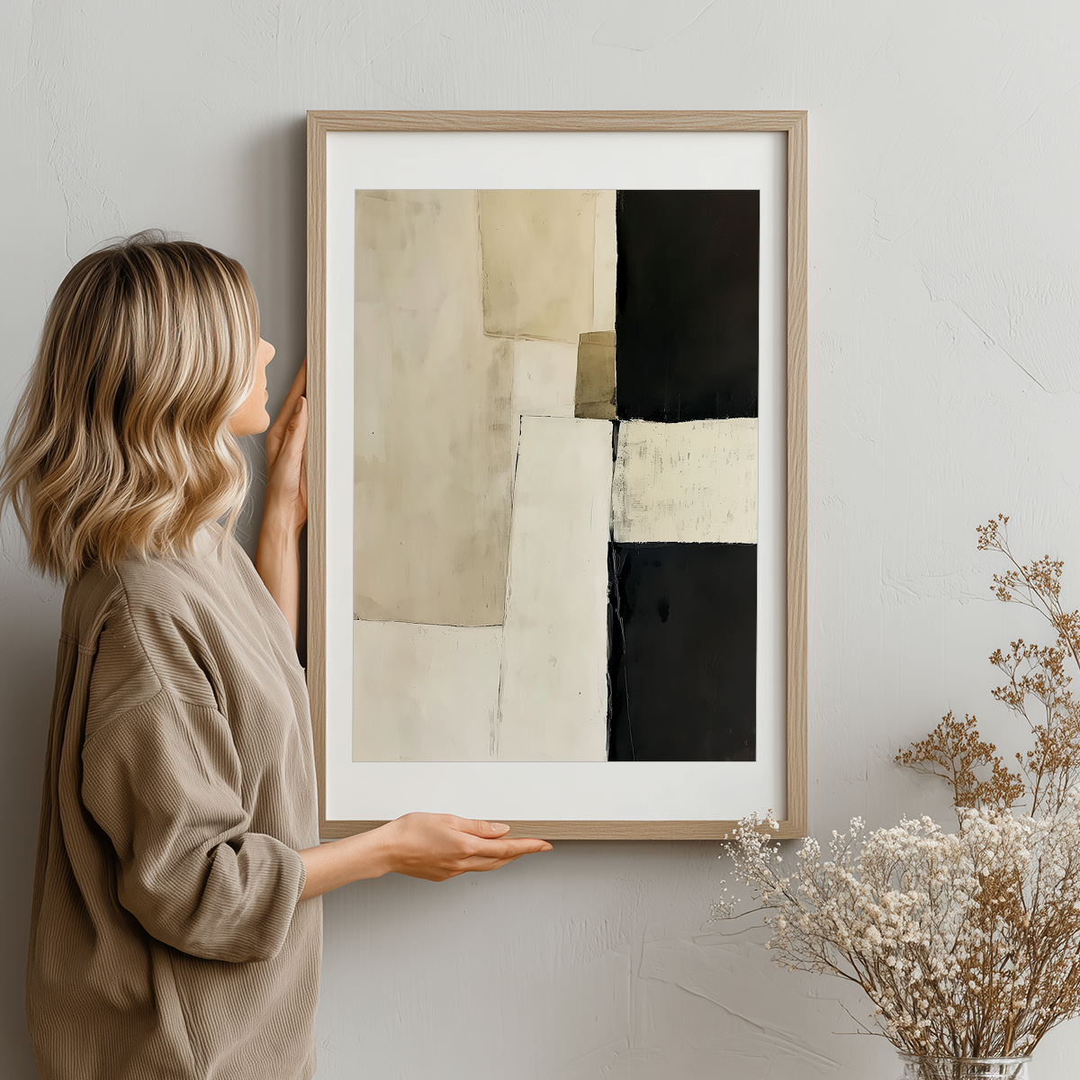 Woman holding Architectural Abstract Wall Art | Modern Neutral Geometric Canvas | Textured Minimalist Decor featuring muted beige, black, and cream abstract geometric shapes in a light wooden frame.