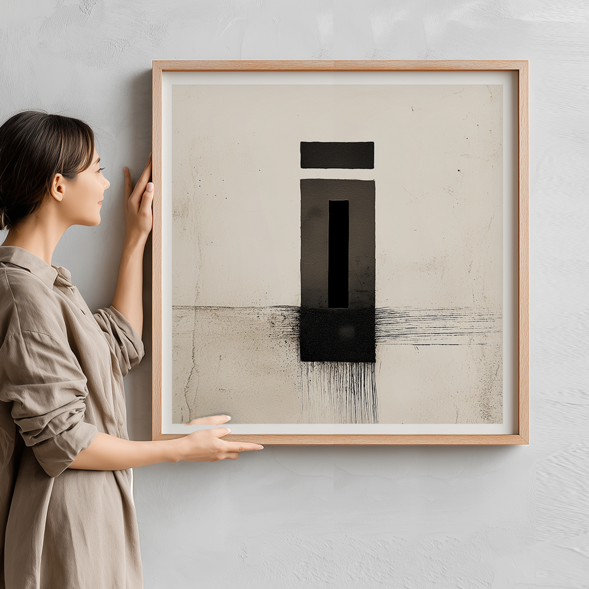 Woman holding a framed Zen Abstract Wall Art Print – Minimalist Black Ink Geometric Modern Decor featuring bold black shapes and textured lines on a neutral background.
