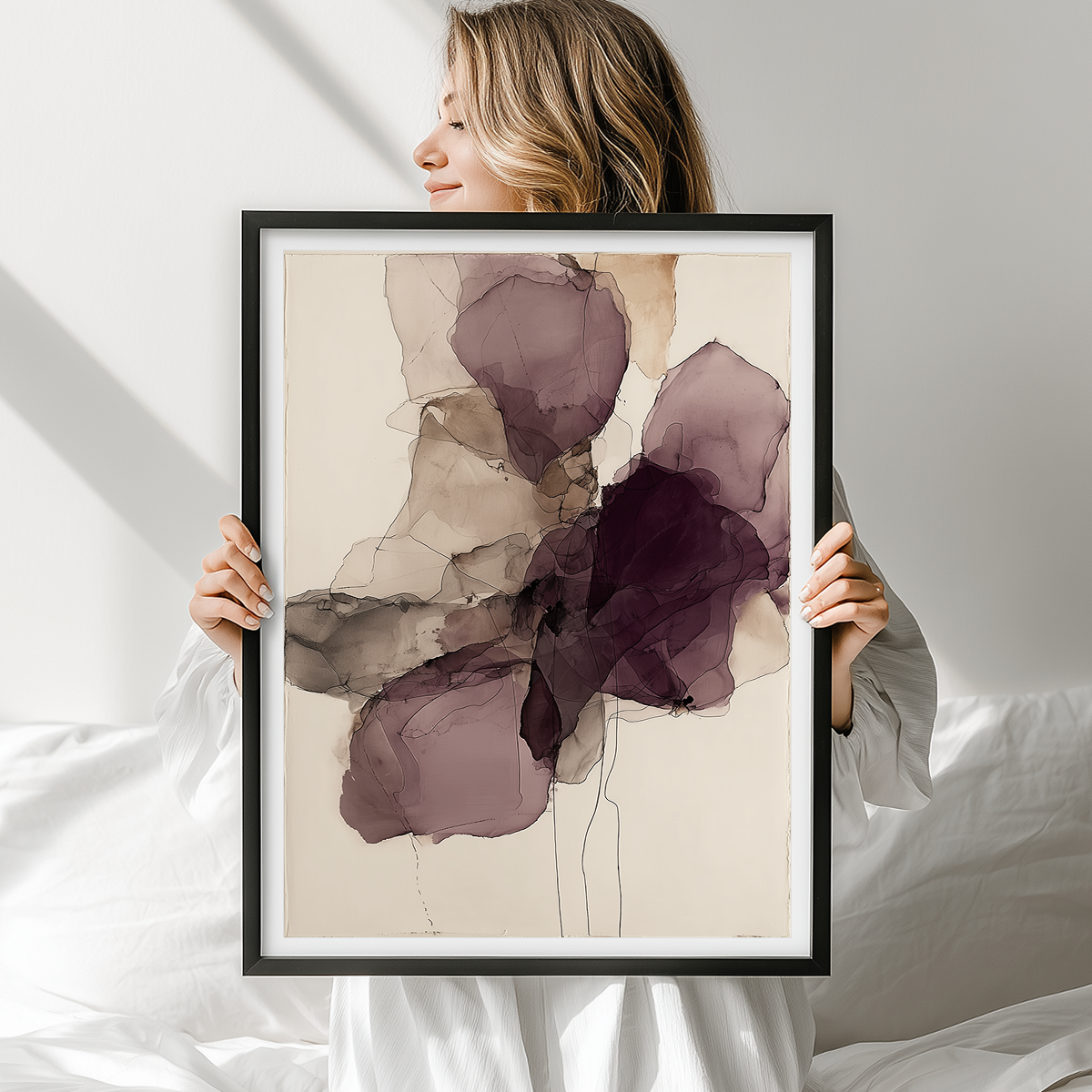 Woman holding framed Ink Wash Abstract Floral Wall Canvas Art Print - Burgundy Minimalist Modern Wall Art featuring soft layered burgundy and neutral ink wash floral shapes on a light background.