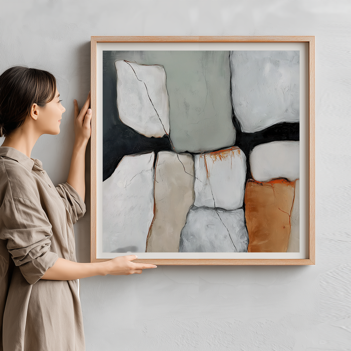 Woman holding Wabi-Sabi Abstract Wall Art | Earth Tone Minimalist Print | Sage Green & Burnt Orange Decor featuring neutral and muted abstract shapes with black lines and soft textures in a wooden frame.