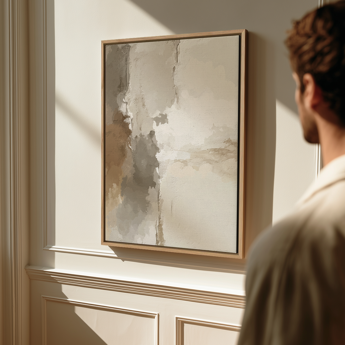 A man views Japandi Abstract Wall Art | Neutral Textured Plaster Canvas featuring a minimalist, neutral-toned abstract design with textured plaster effect in a modern, sunlit room.