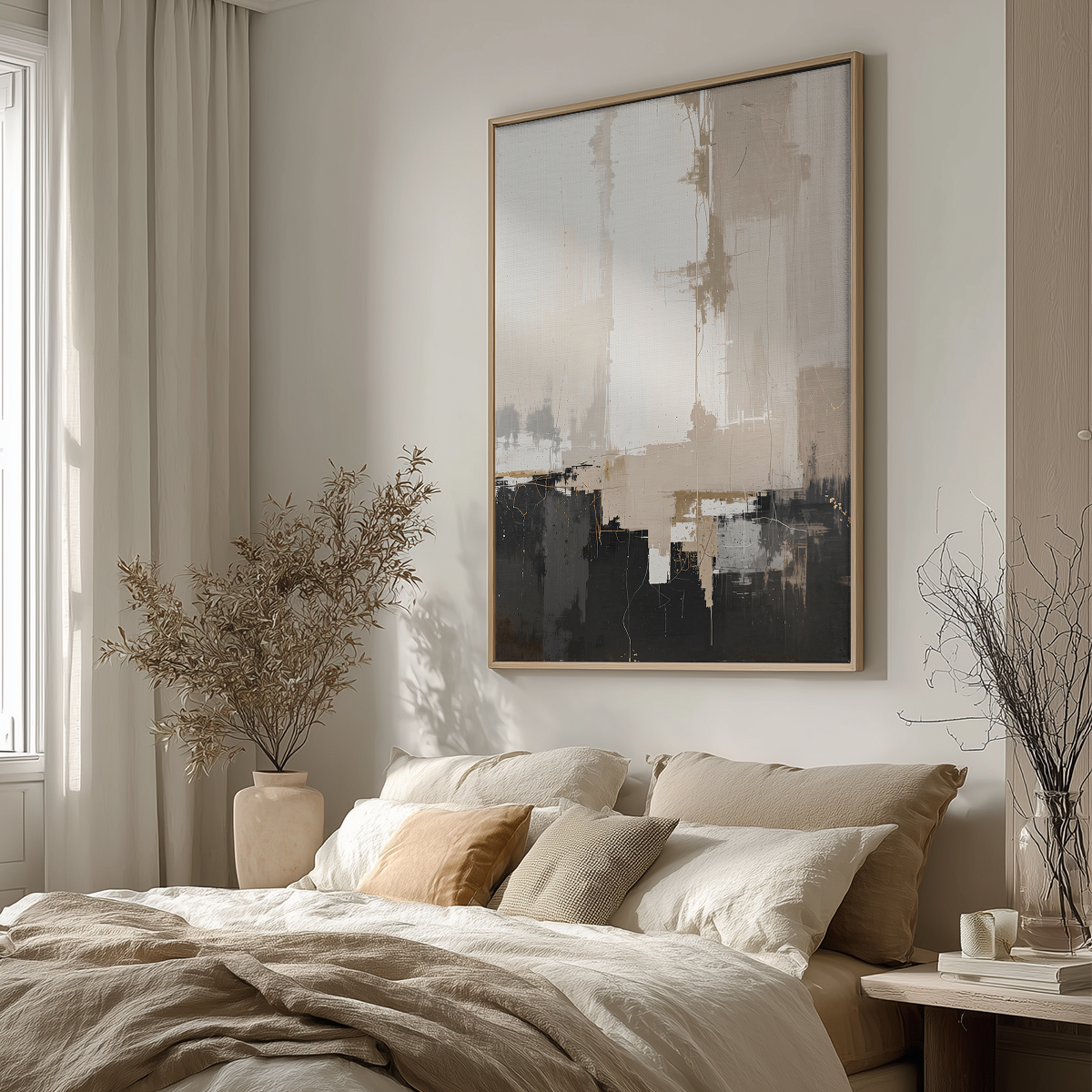 A large framed abstract wall art print hangs above a neatly made bed in a softly lit bedroom. The artwork features layered brushstrokes in beige, gray, black, and white, with a light wood frame.
