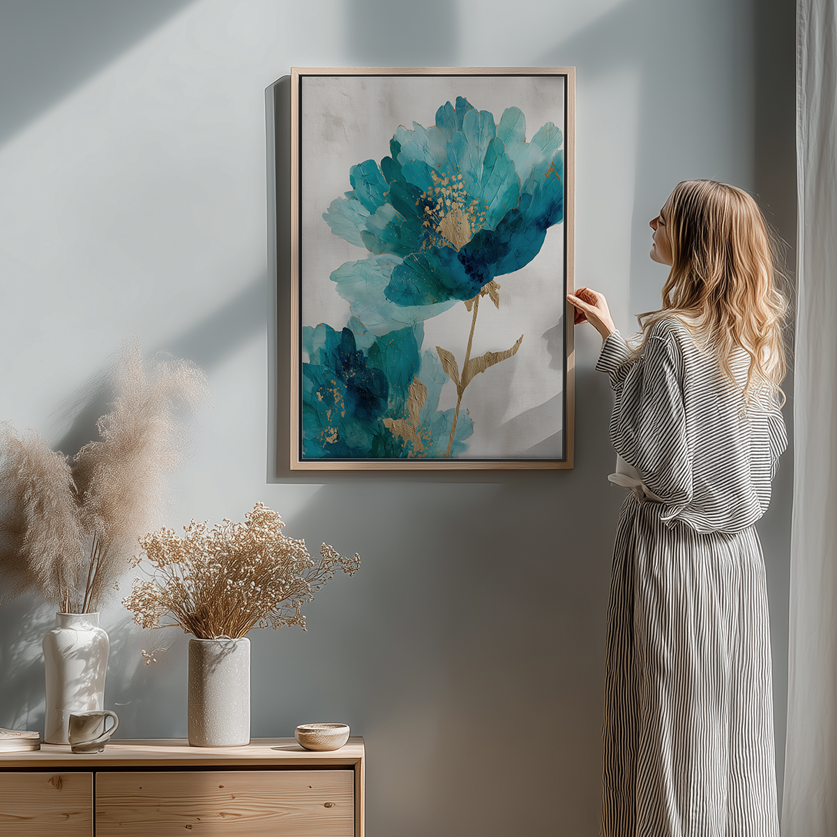Woman admiring Blue Infusion Abstract Floral Wall Art | Teal & Indigo Botanical Canvas | Modern Luxe Decor in a softly lit, minimalist room with neutral decor and dried floral arrangements.
